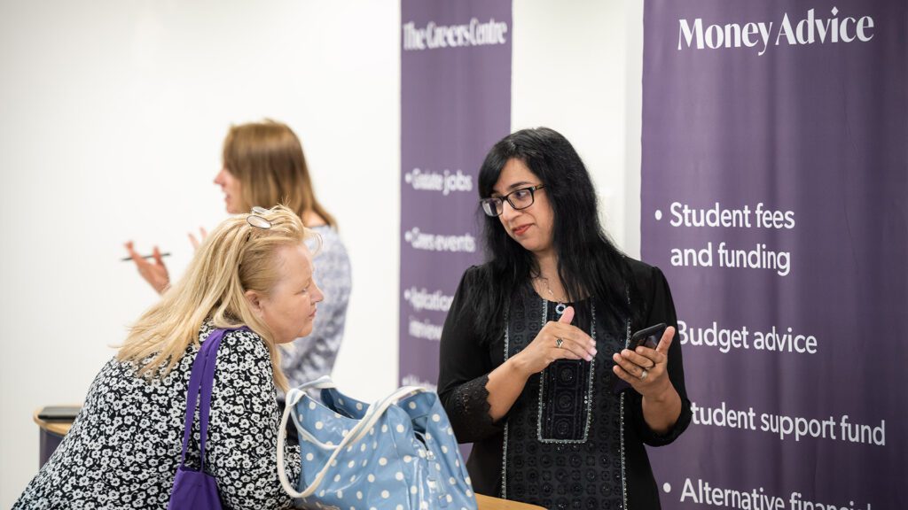 mature female student at the money advice stand getting support for female member of staff